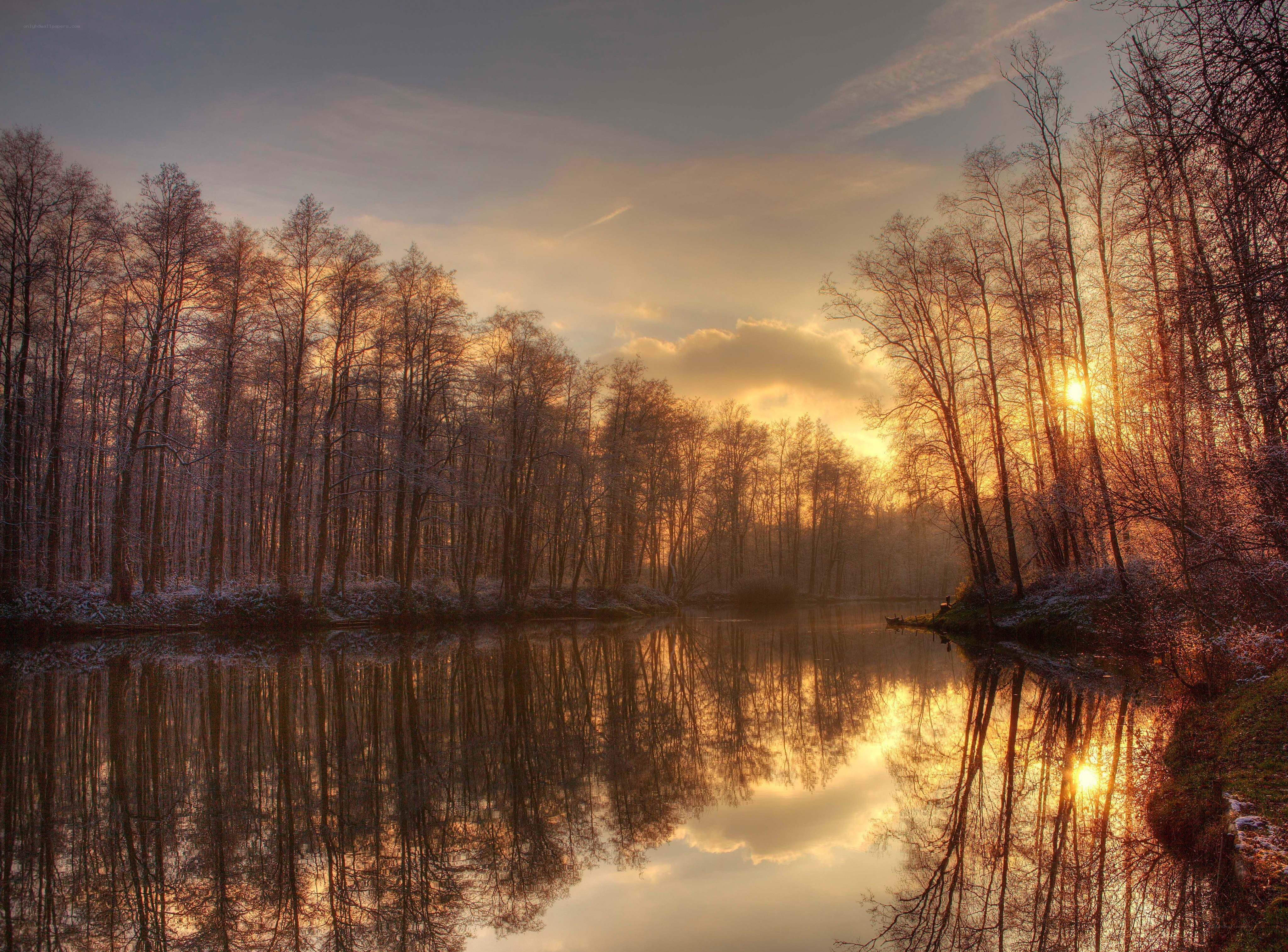 Sunset over a snowy forest lake