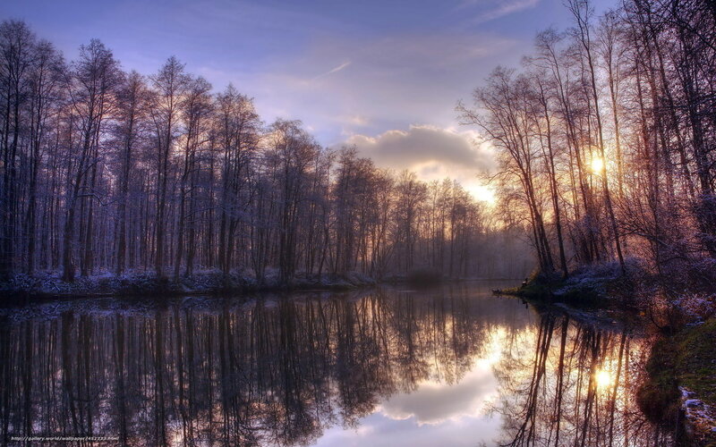 Sunset over a snowy forest lake