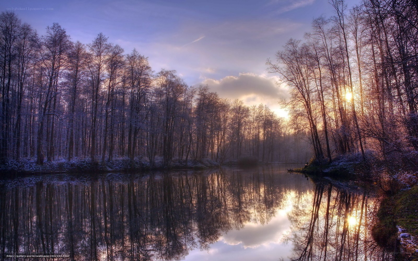 Sunset over a snowy forest lake