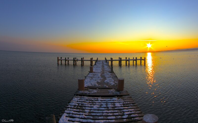 Sunset over a snowy pier