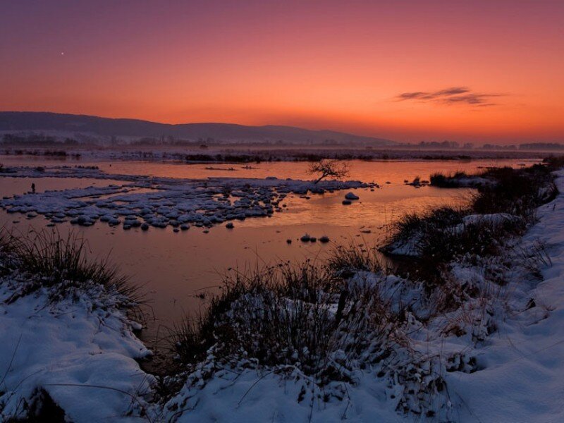 sunset over a snowy river