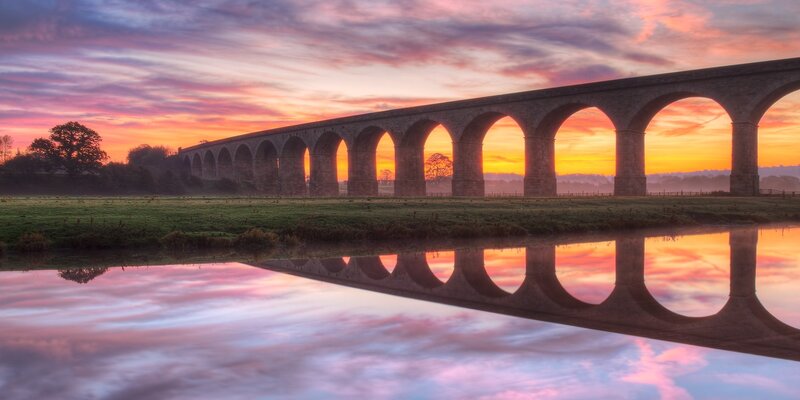 Sunset over a stone aqueduct