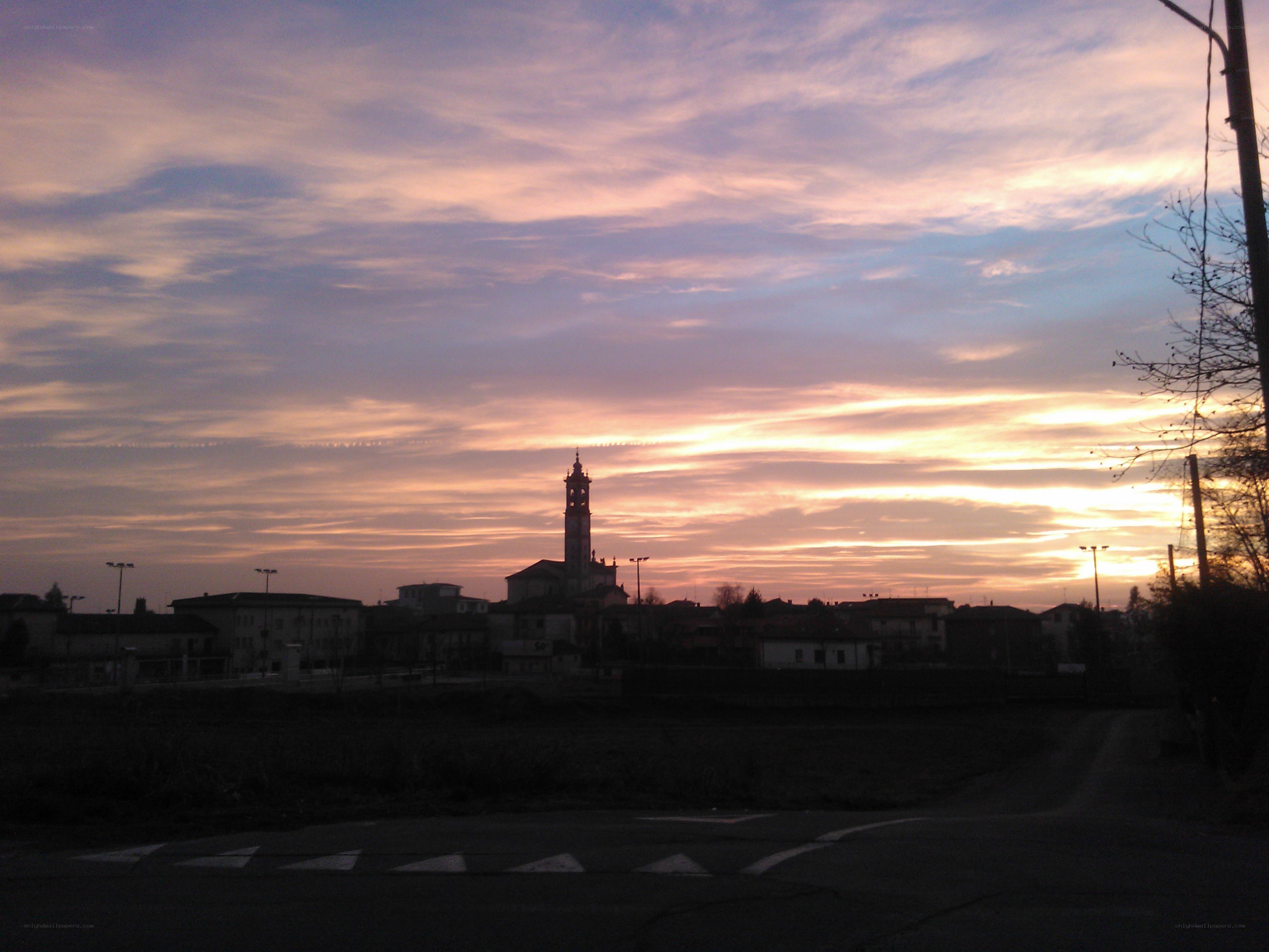 sunset over a town with church