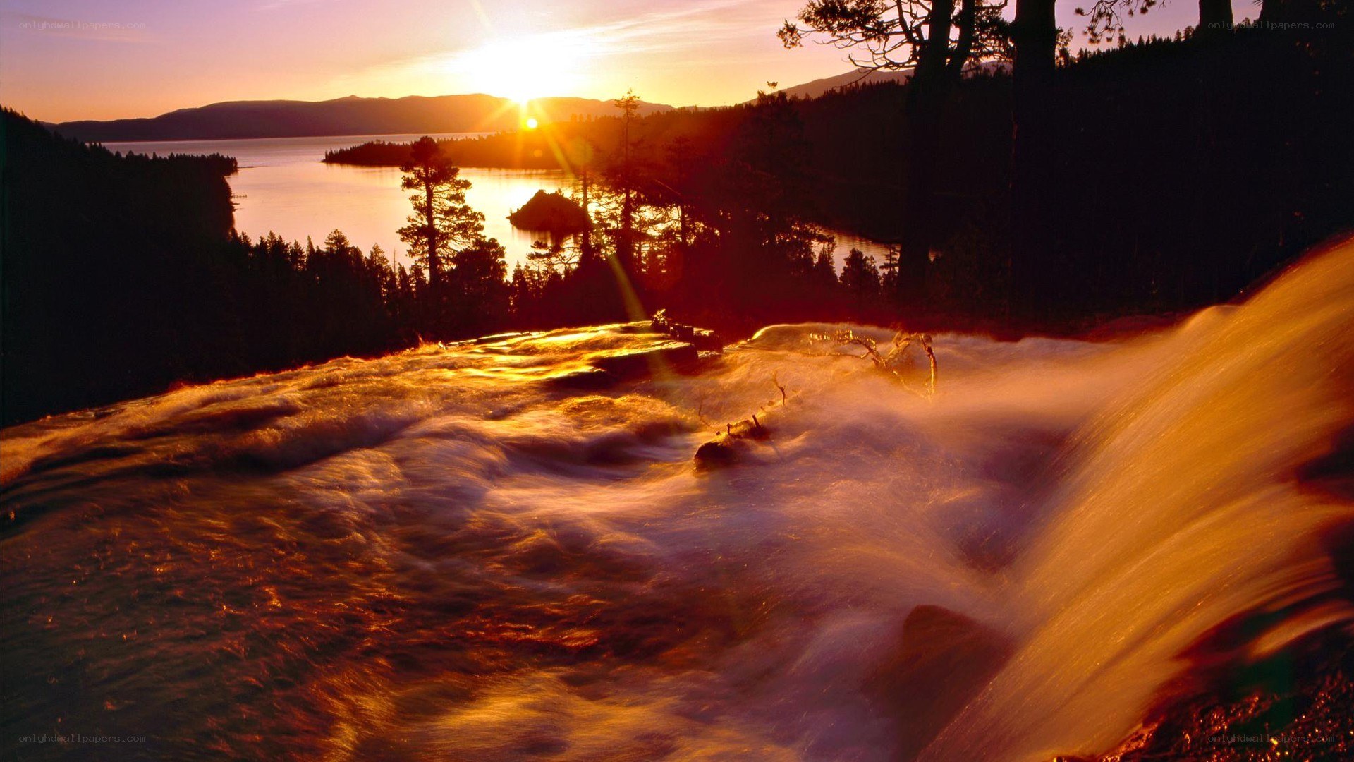 sunset over a waterfall and lake