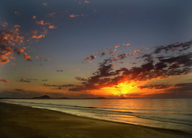 Sunset over Beach — Orange, Dramatic, Photograph, Ocean, Clouds, Mountains