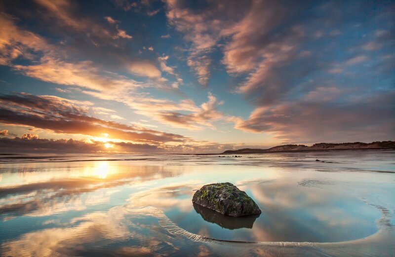Sunset over beach with rock