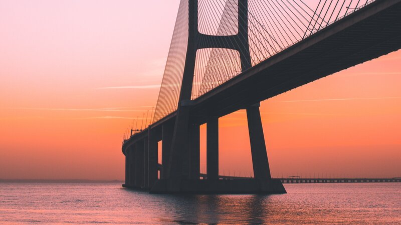Sunset over Cable-stayed Bridge — Orange, Serene, Photograph, Water, Sky