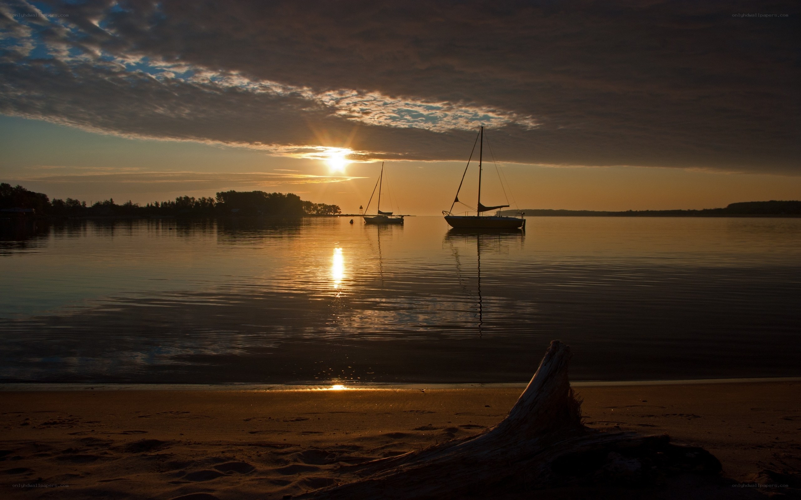Sunset over calm bay with sailboats