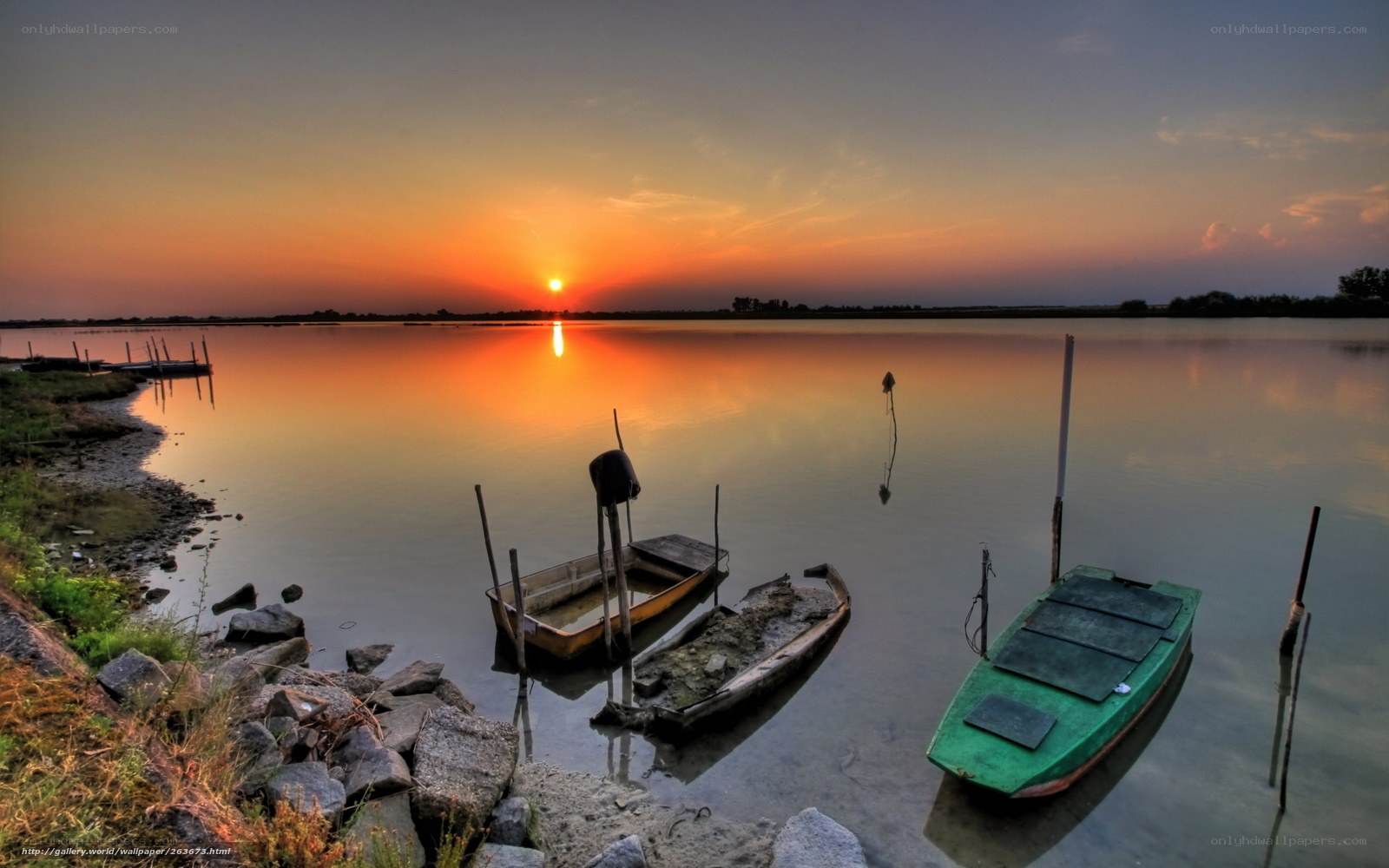 Sunset over calm lake with boats