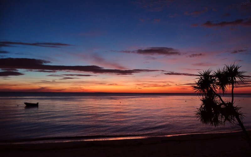Sunset over Calm Sea — Orange, Serene, Photograph, Boat, Palm Tree