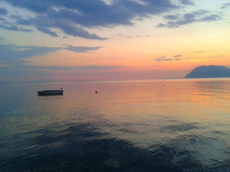 Sunset over calm sea with boat