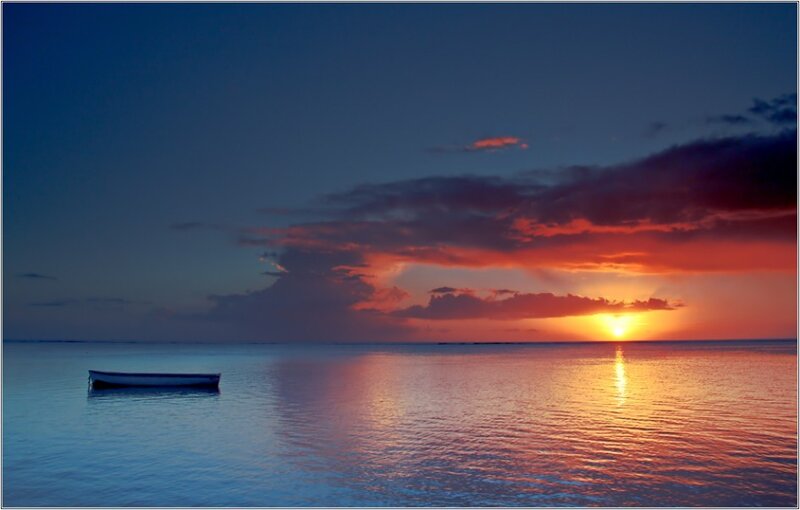 Sunset over calm sea with boat