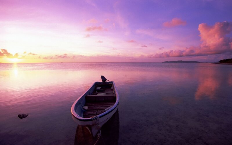 Sunset over calm sea with boat