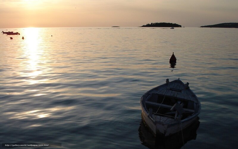 Sunset over calm sea with boats