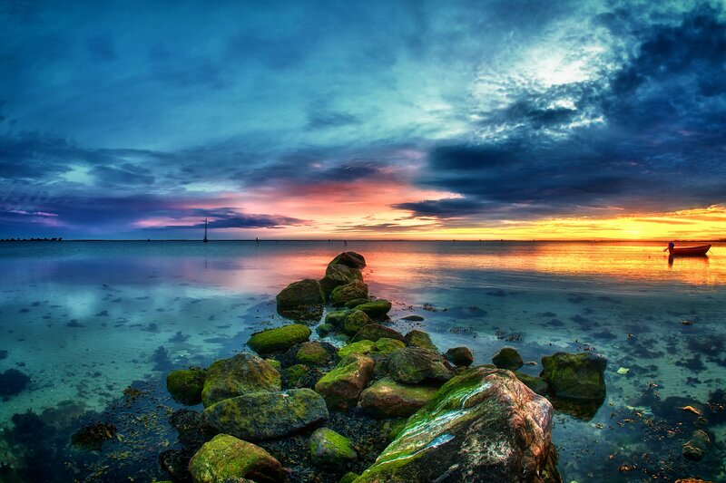 Sunset over calm sea with rocks