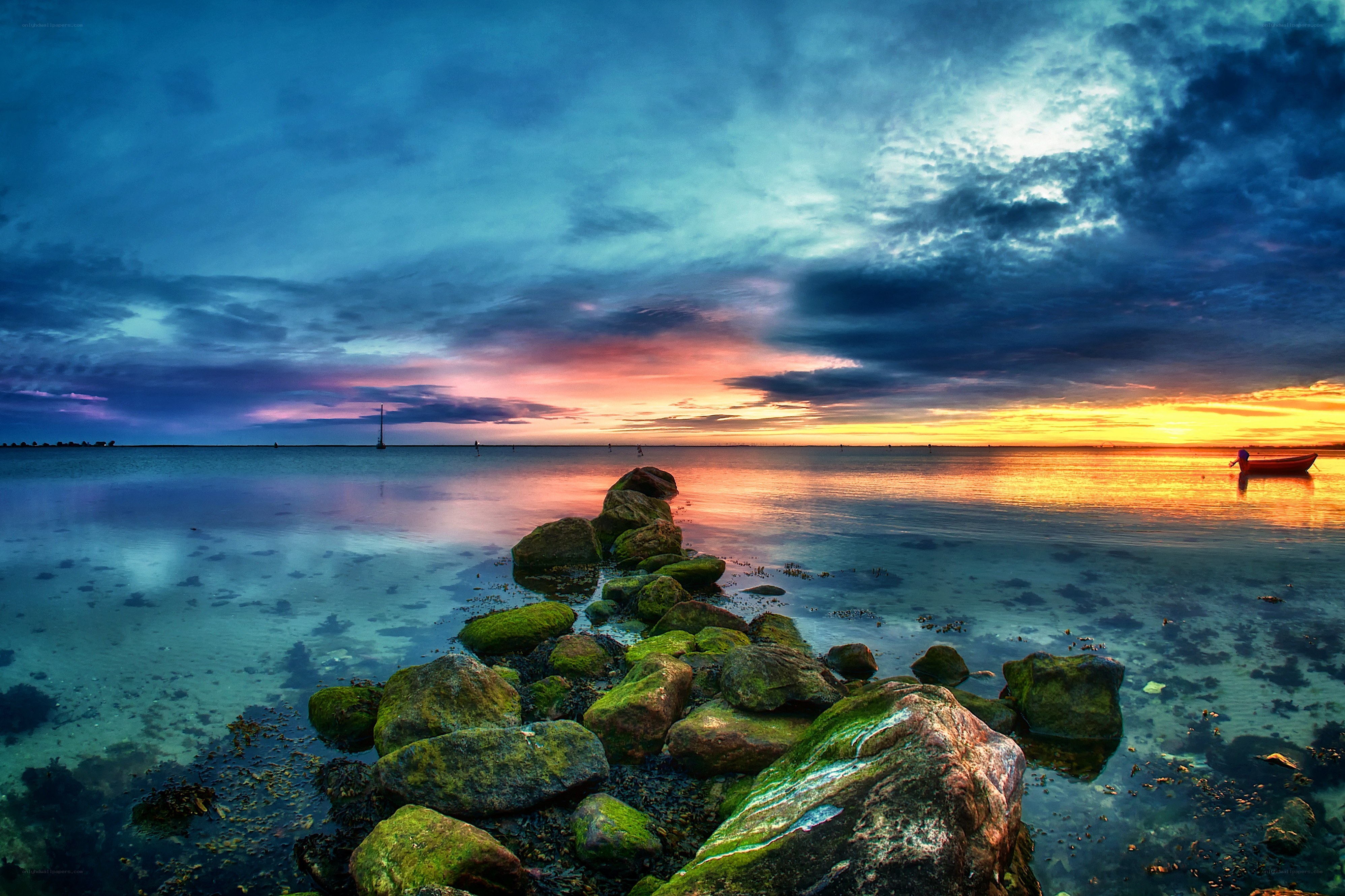 Sunset over calm sea with rocks