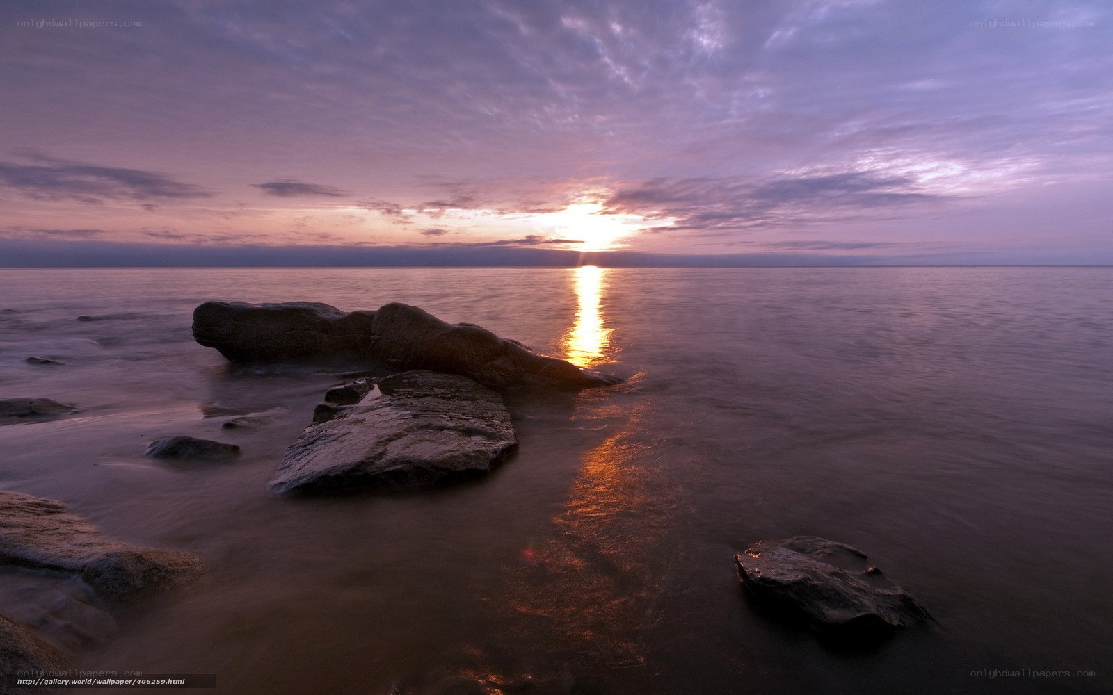 Sunset over calm sea with rocks