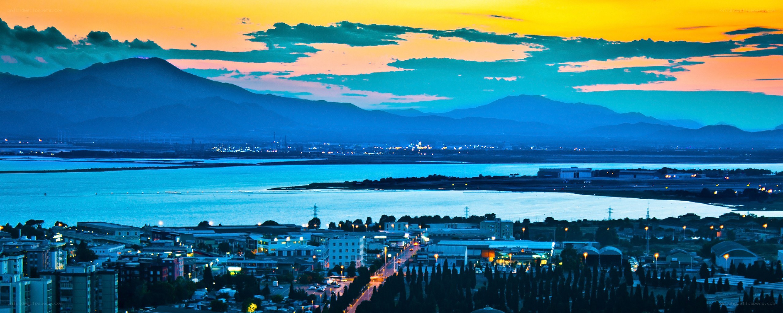 sunset over coastal city and mountains