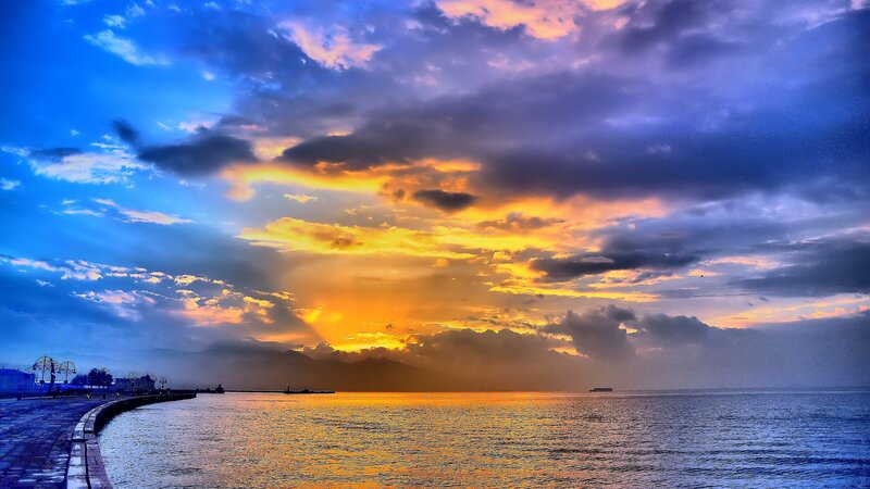 Sunset over Coastal City — Blue, Dramatic, Photograph, Sea
