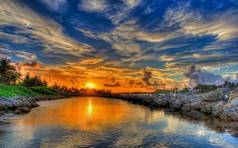 Sunset over Coastal Inlet — Orange, Dramatic, Photograph, Palm Trees, Rocks, Lighthouse
