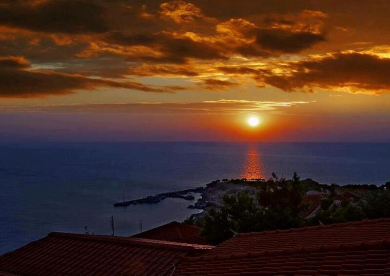 Sunset over Coastal Town — Orange, Dramatic, Photograph, Sea