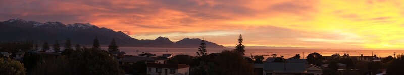 Sunset over Coastal Town — Orange, Serene, Photograph, Mountains, Sea