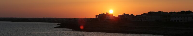 Sunset over Coastal Town — Orange, Serene, Photograph, Sun, Buildings