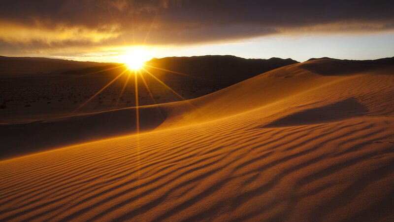 Sunset over desert dunes