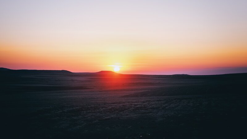 sunset over desert hills