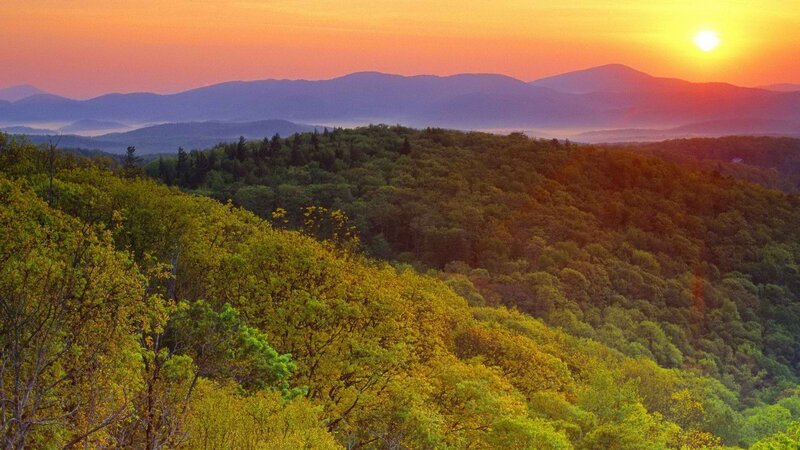 Sunset over forested mountains