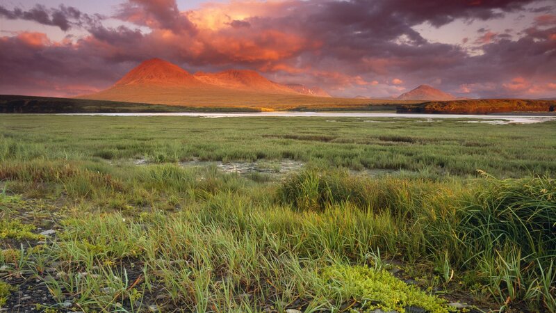 Sunset over grassy marsh and mountains