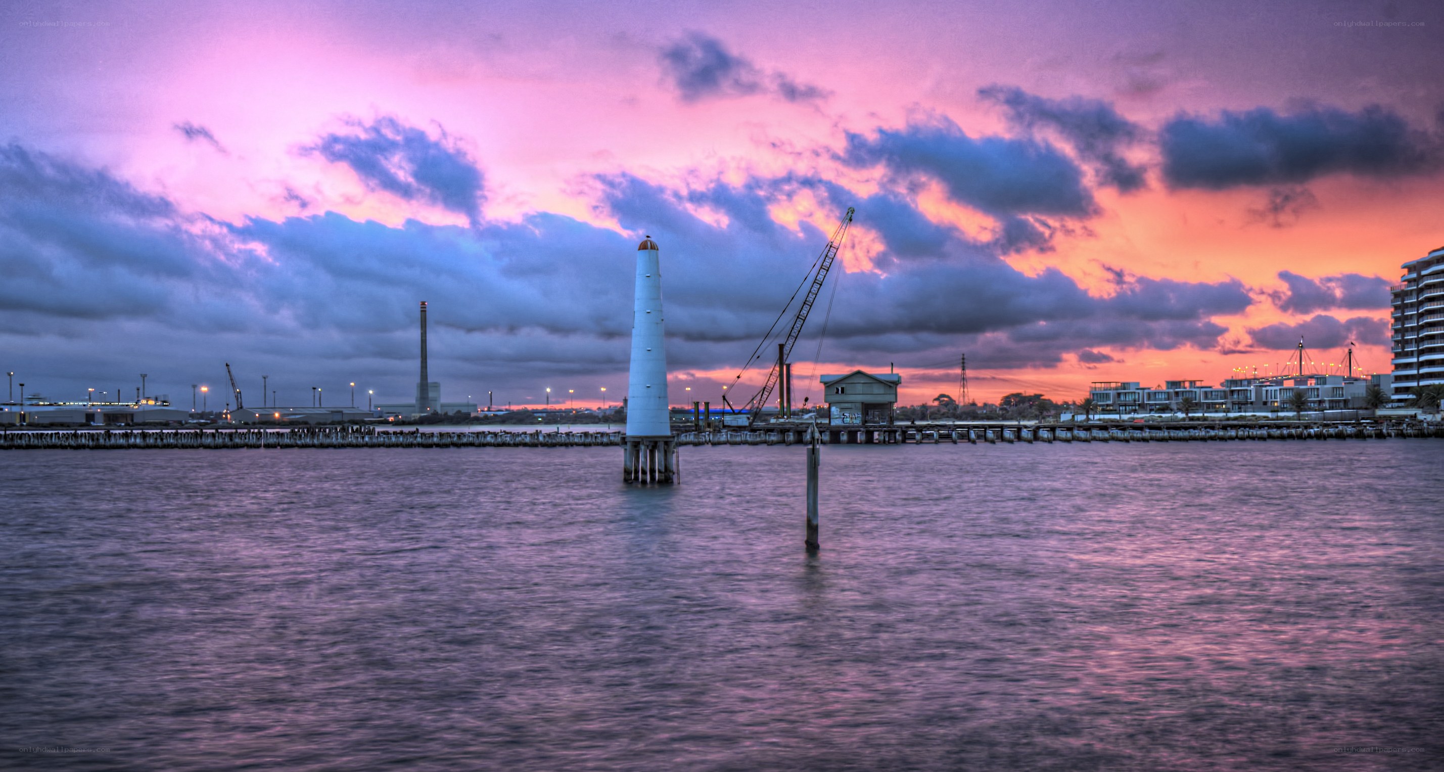 sunset over harbor with lighthouse