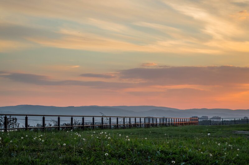 Sunset over hills and railing