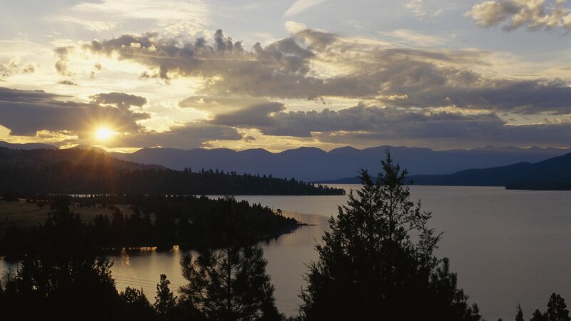 Sunset over Lake and Mountains — Blue, Serene, Photograph, Trees, Sun, Orange