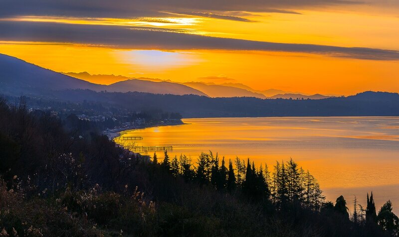 Sunset over Lake and Mountains — Orange, Serene, Photograph, Trees, Town