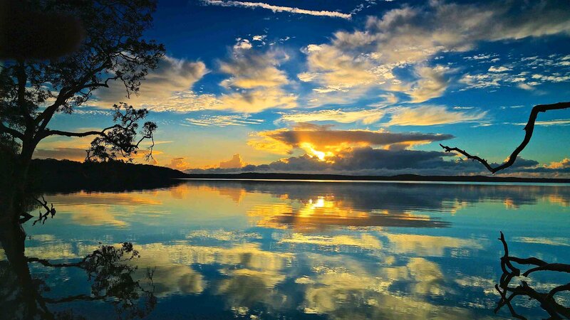 Sunset over Lake — Blue, Serene, Photograph, Tree Branches, Clouds