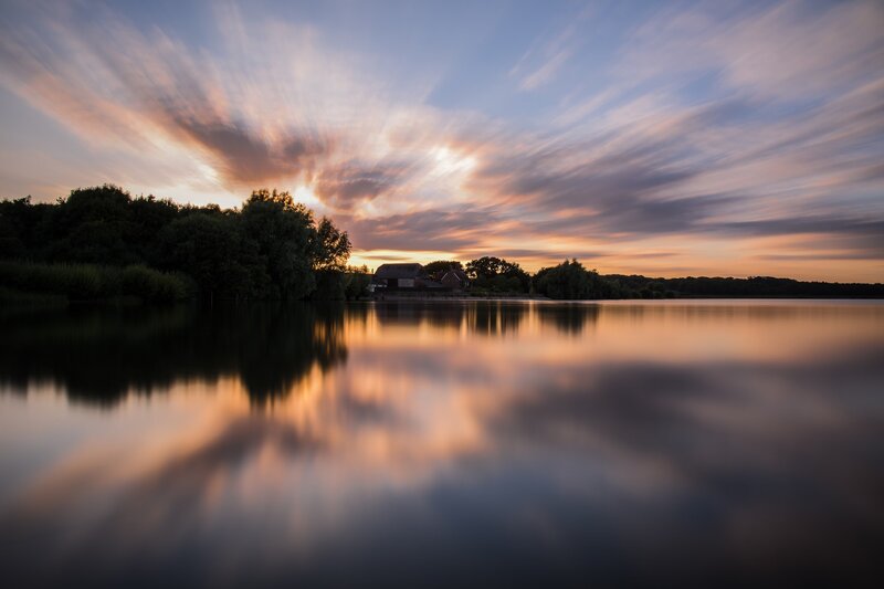 Sunset over Lake — Orange, Serene, Photograph, Clouds, Trees, Building