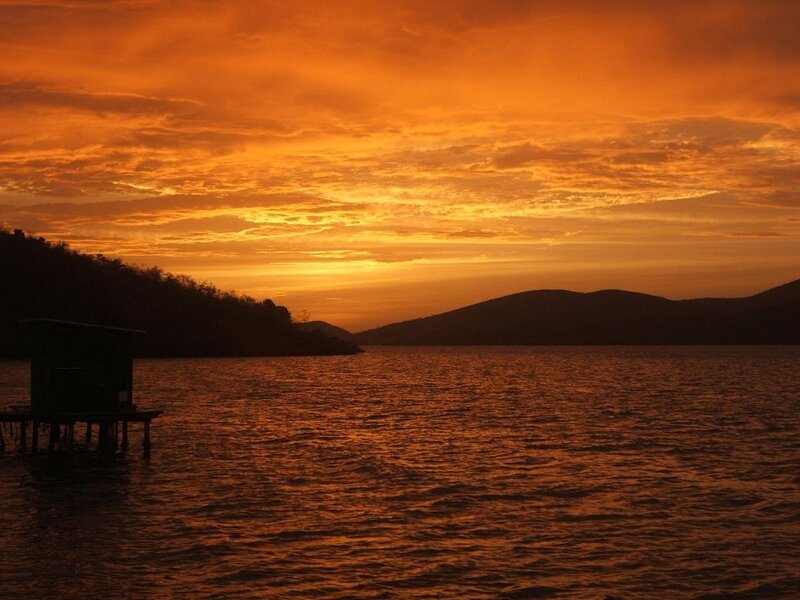 Sunset over Lake — Orange, Serene, Photograph, Mountains, Stilt House