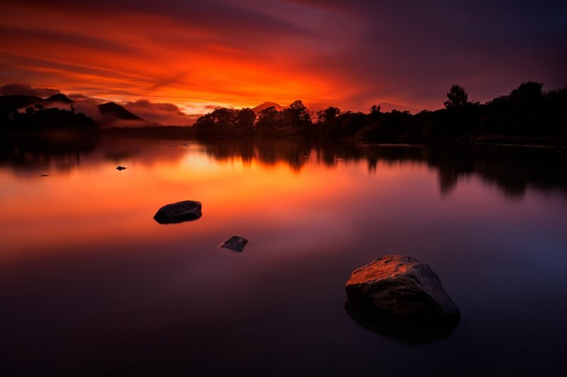 Sunset over Lake — Orange, Serene, Photograph, Rocks, Trees, Mountains