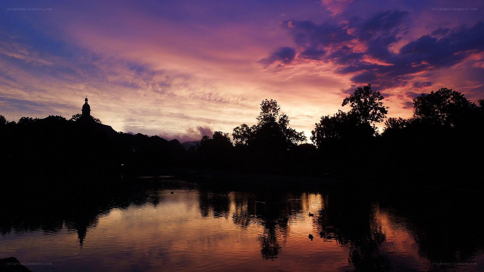 sunset over lake with church