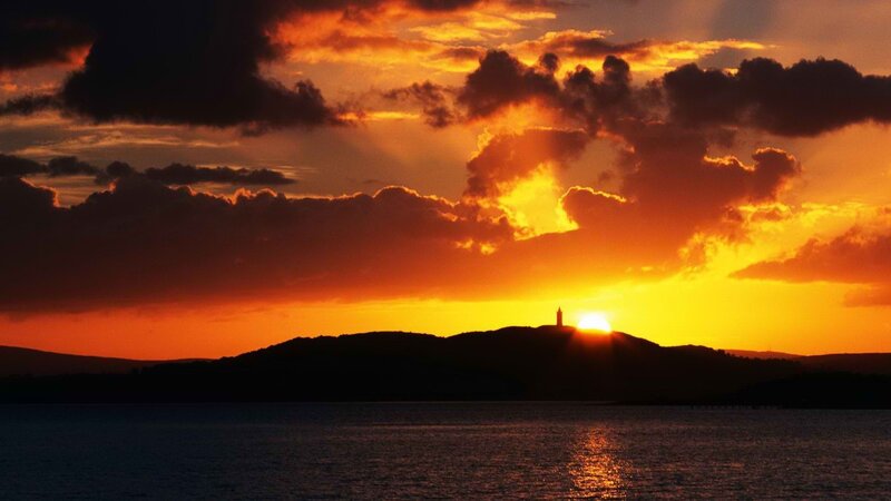 Sunset over lighthouse silhouette