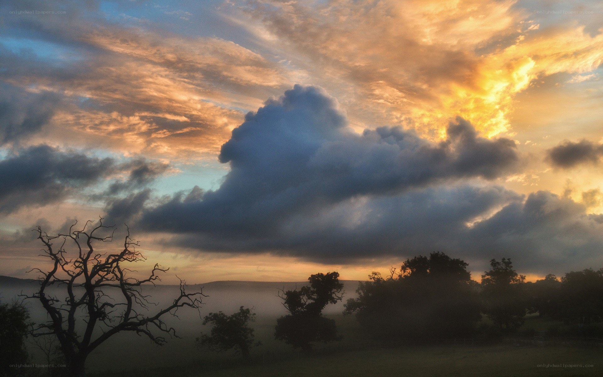 Sunset over misty hills