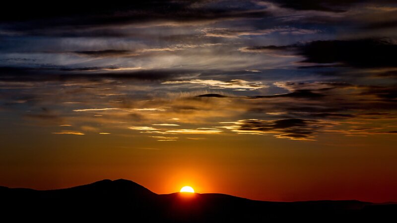 Sunset over mountain silhouette