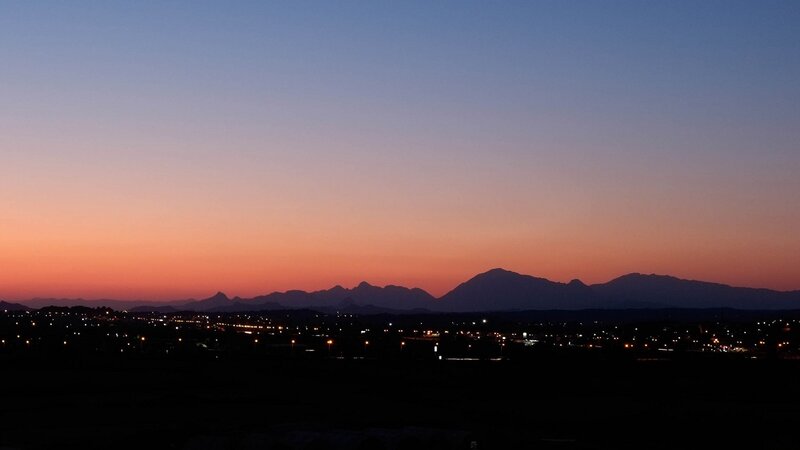 sunset over mountains and city