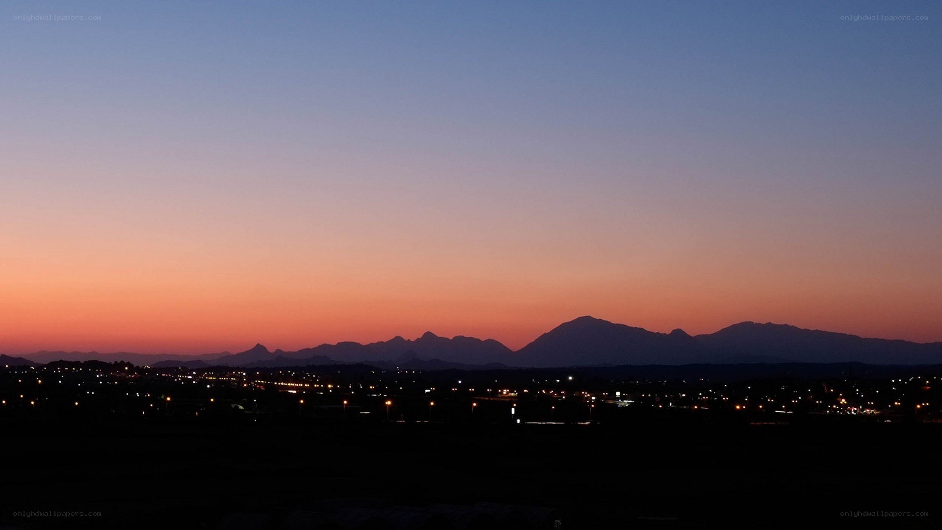 sunset over mountains and city