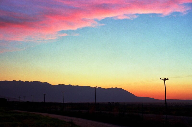Sunset over mountains and power lines