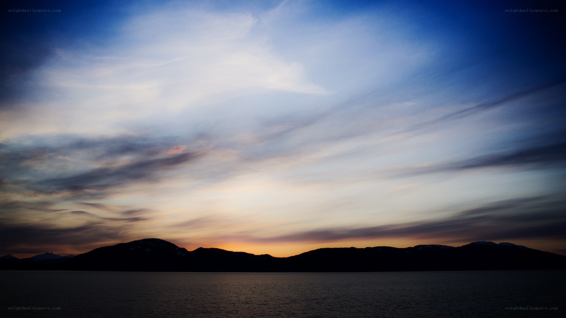 sunset over mountains and water