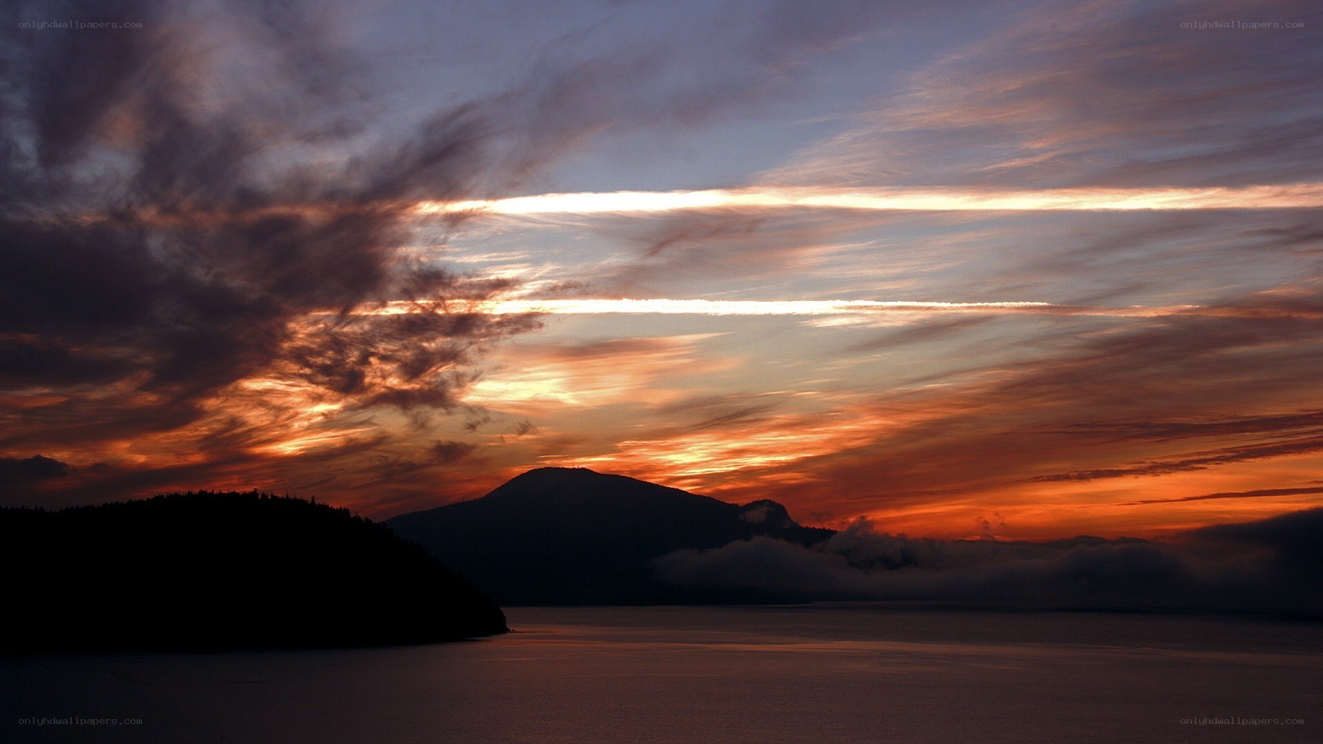 sunset over mountains and water