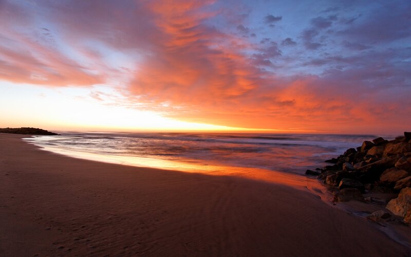 Sunset over Ocean Beach — Orange, Dramatic, Photograph, Sand, Rocks, Waves