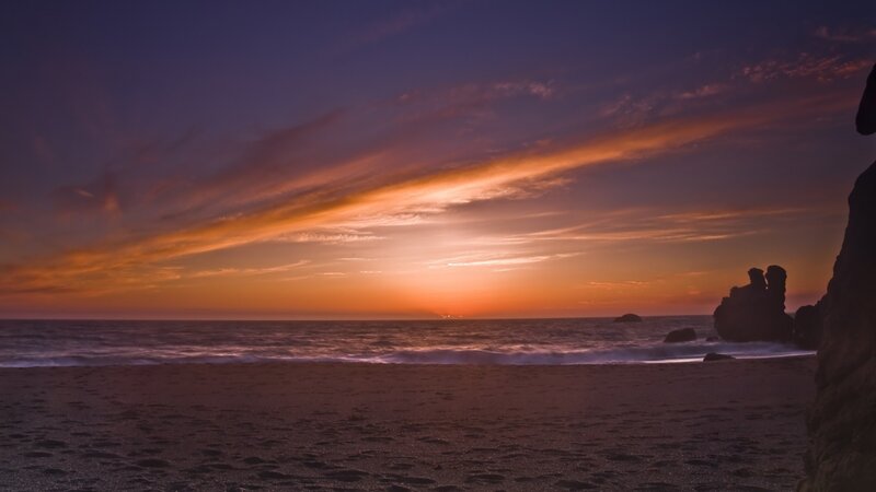 Sunset over Ocean Beach — Orange, Serene, Photograph, Sand, Rocks, Purple, Blue